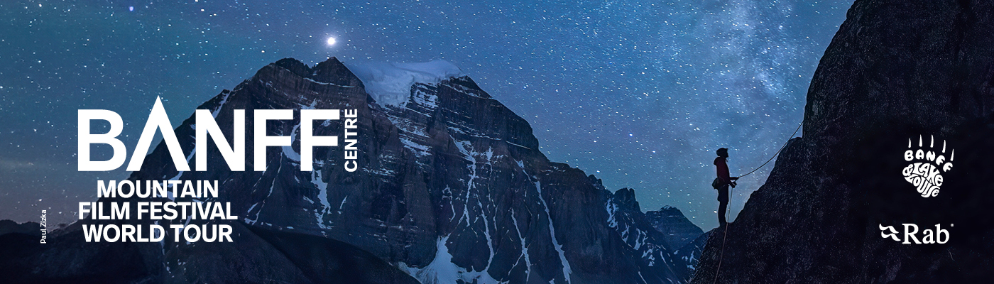 “Nighttime mountain landscape under a star-filled sky. A climber is silhouetted while ascending a steep rock face on the right, with snow-covered peaks in the background. Large text reads ‘BANFF Centre Mountain Film Festival World Tour,’ with Banff Centre Mountain Film Festival and Rab logos on the right.”